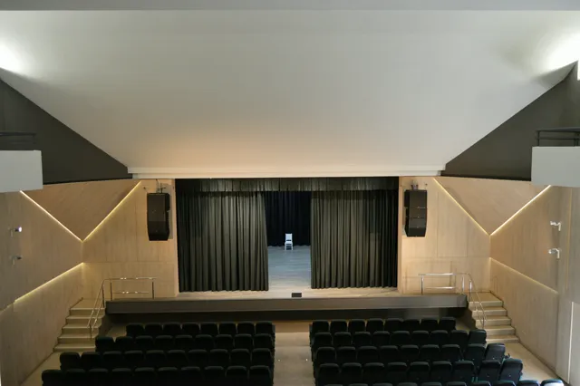 Sala con escenario y sistema de audio profesional